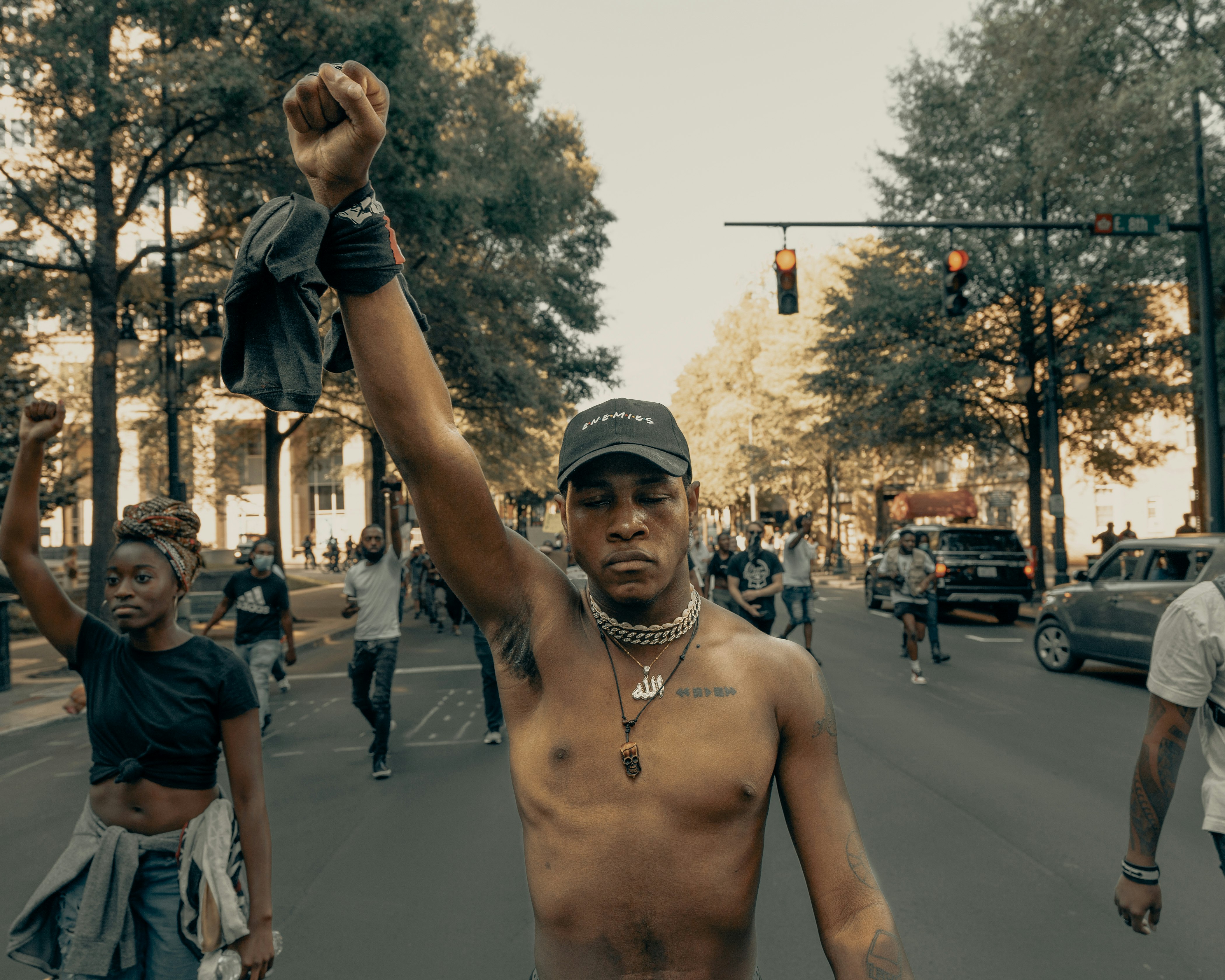 man in black cap and black shorts standing on road during daytime